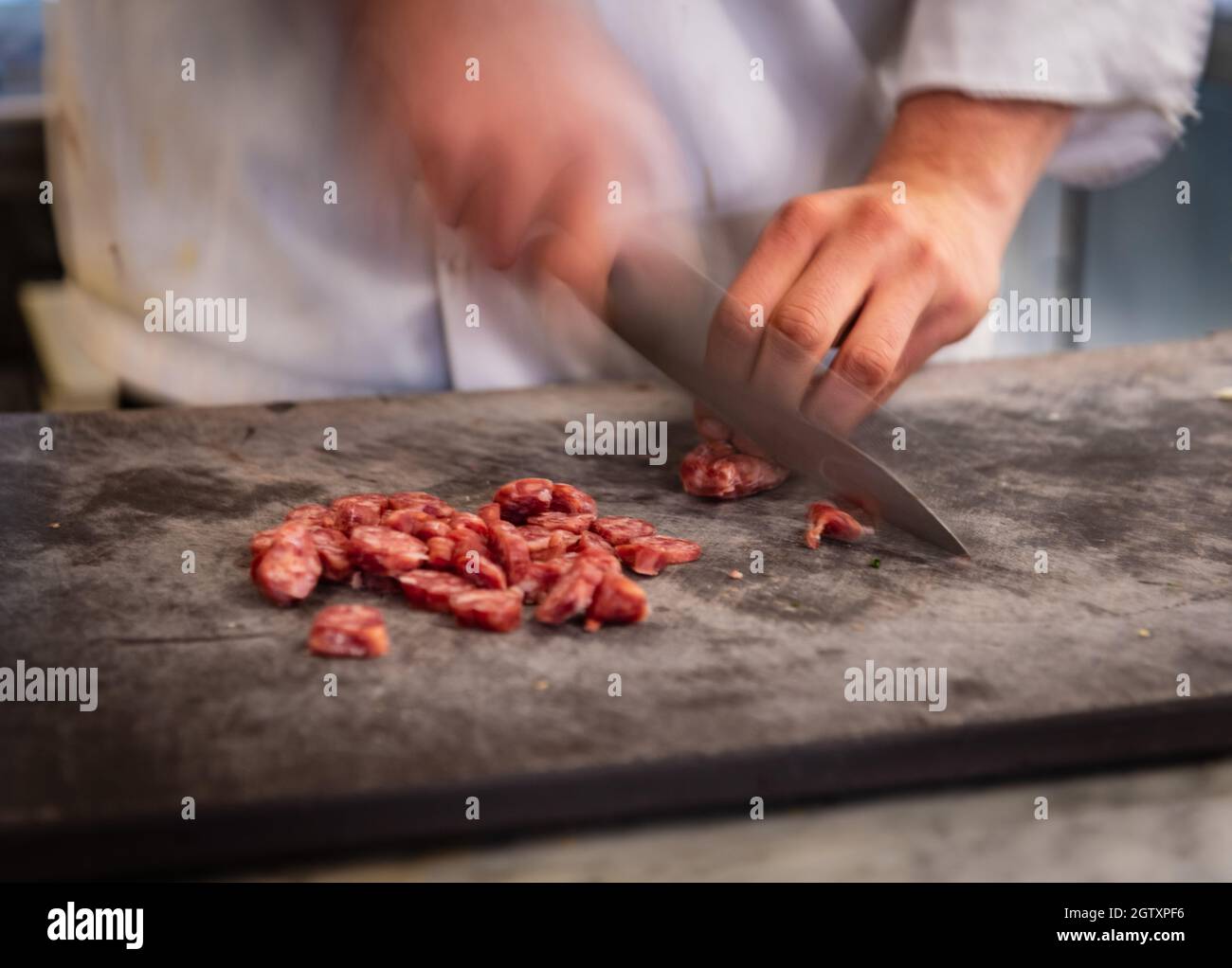 Midsection Of Chef Cutting Meat On Cutting Board Stock Photo