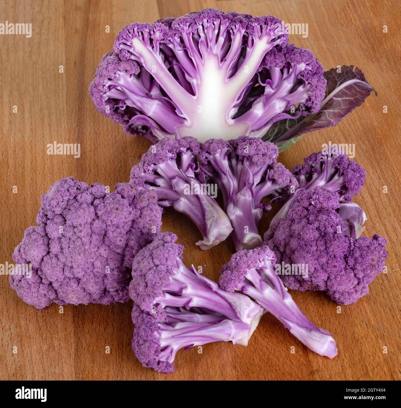 Close-up Of Purple Cauliflowers On Wooden Table Stock Photo