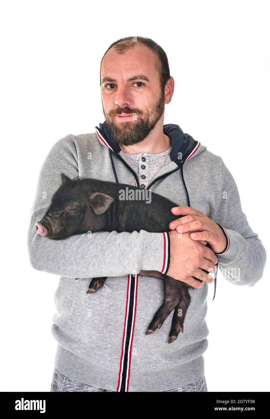 Portrait Of Man Holding Piglet While Standing Against White Background Stock Photo