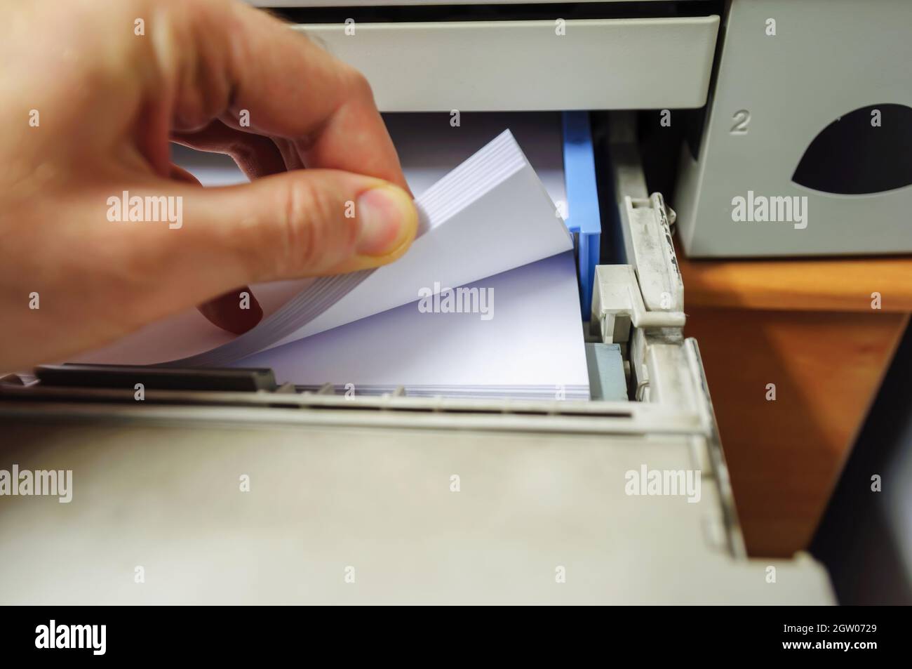 Male hand counting the stack of white paper in laser printer Stock