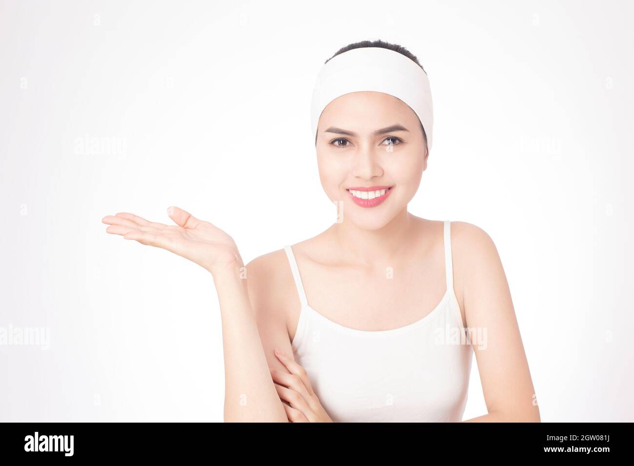 Portrait Of Smiling Young Woman Gesturing Over White Background Stock Photo