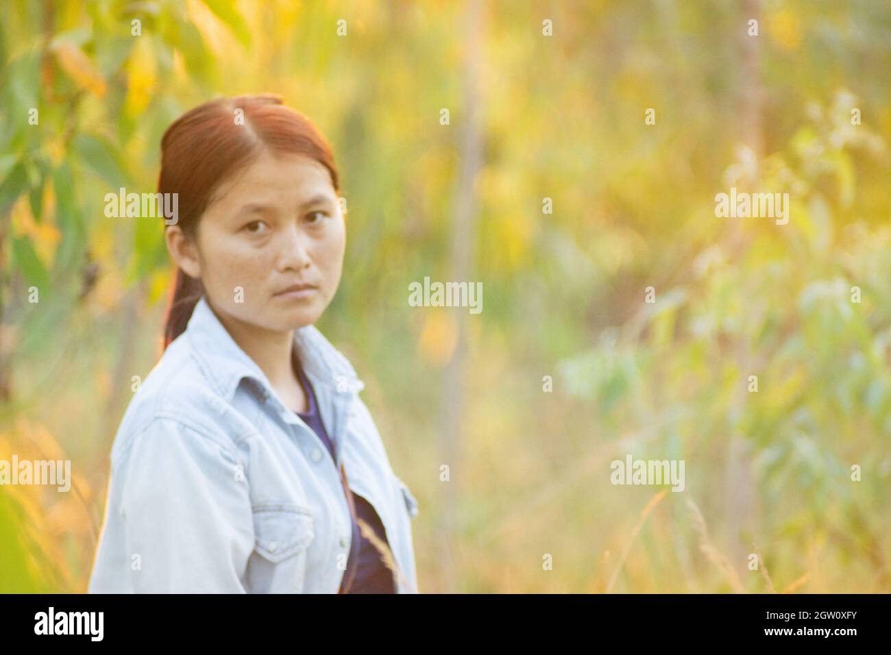 Portrait Of Young Woman Standing Against Plants Stock Photo