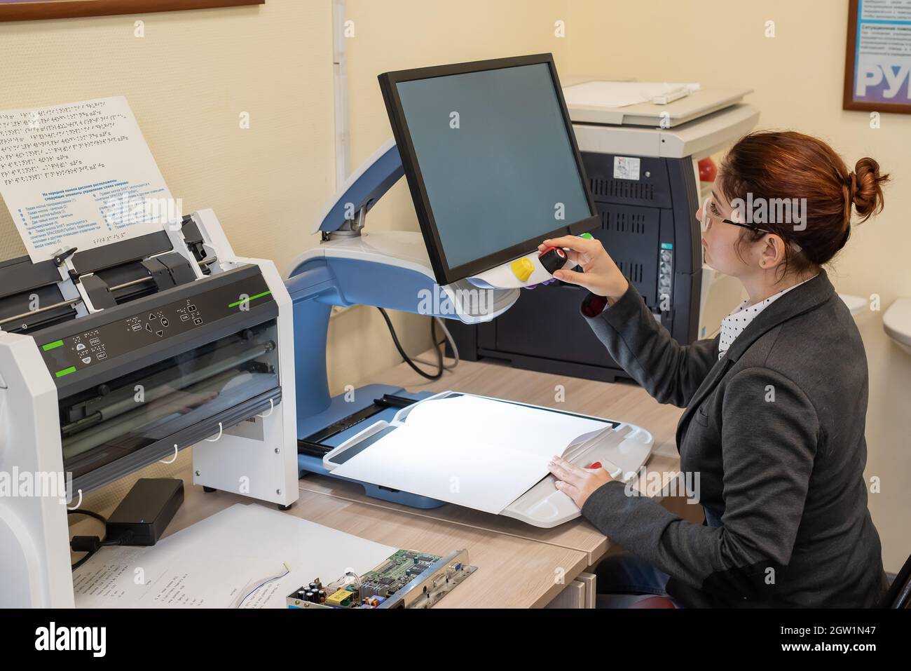 A visually impaired woman uses special reading equipment Stock Photo