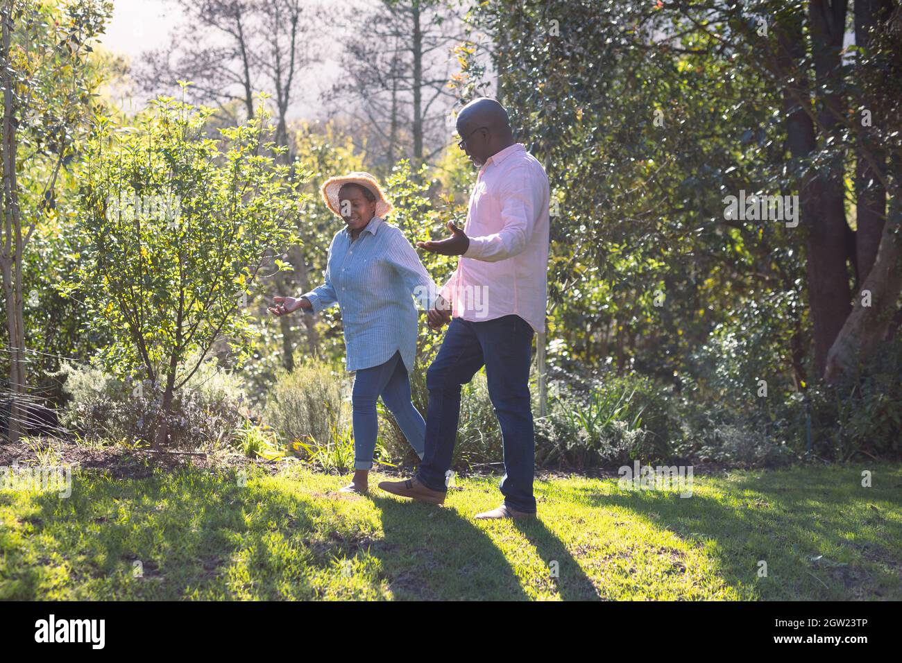 Happy african american senior couple walking, holding hands outdoors ...