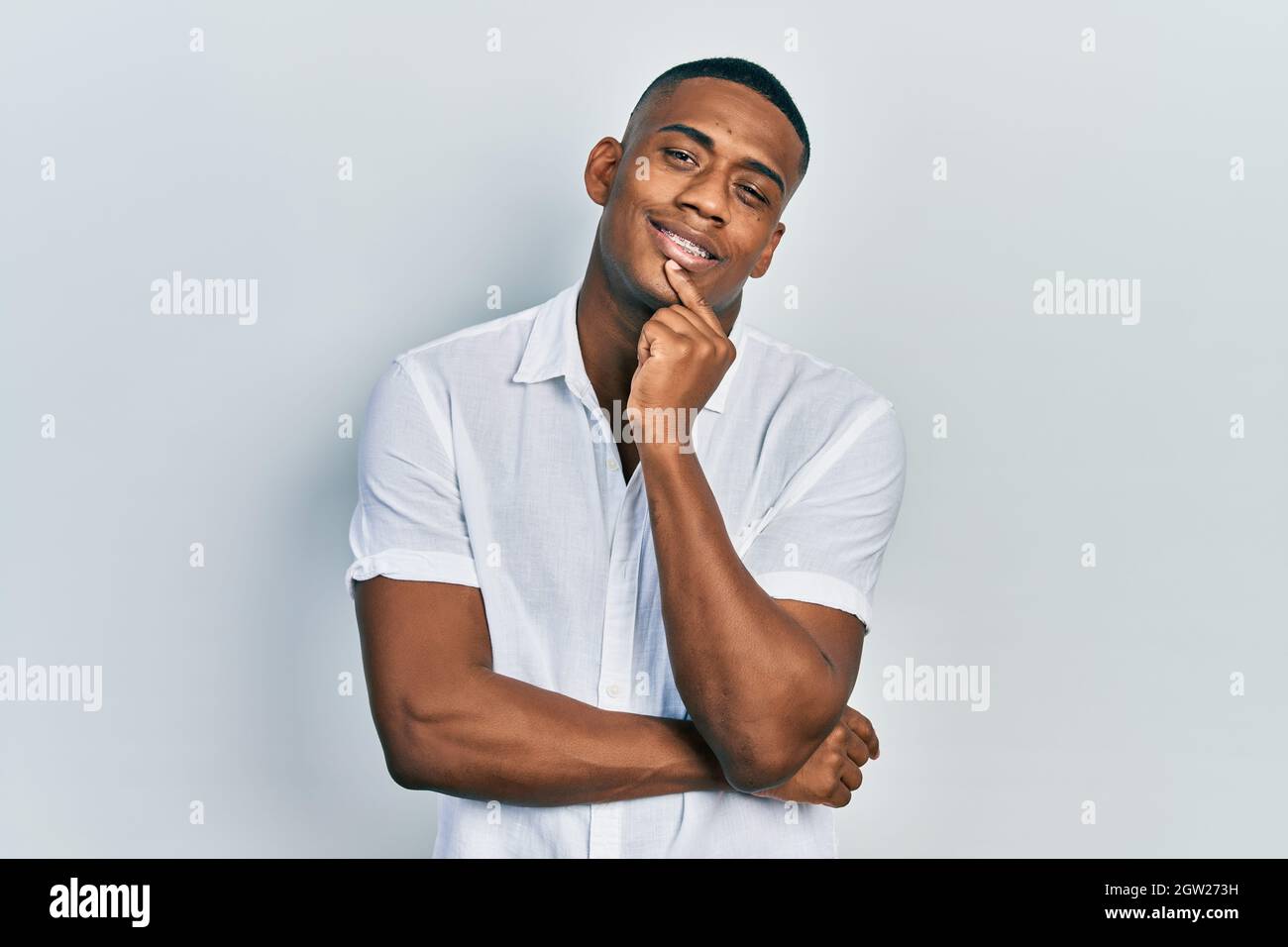 Young black man wearing casual white shirt looking confident at the ...