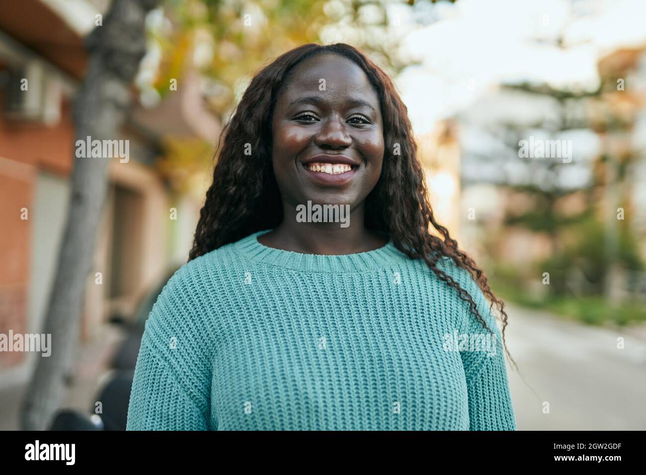 Young african woman smiling happy at the city Stock Photo - Alamy