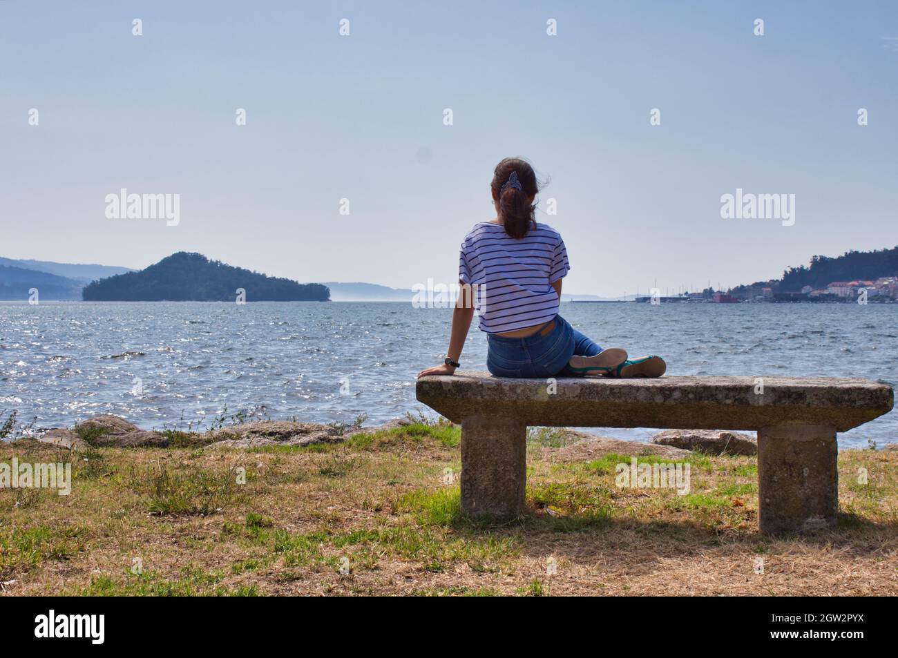 Gils Sitting On A Bench A Looking At Tambo Island In Poio Stock Photo
