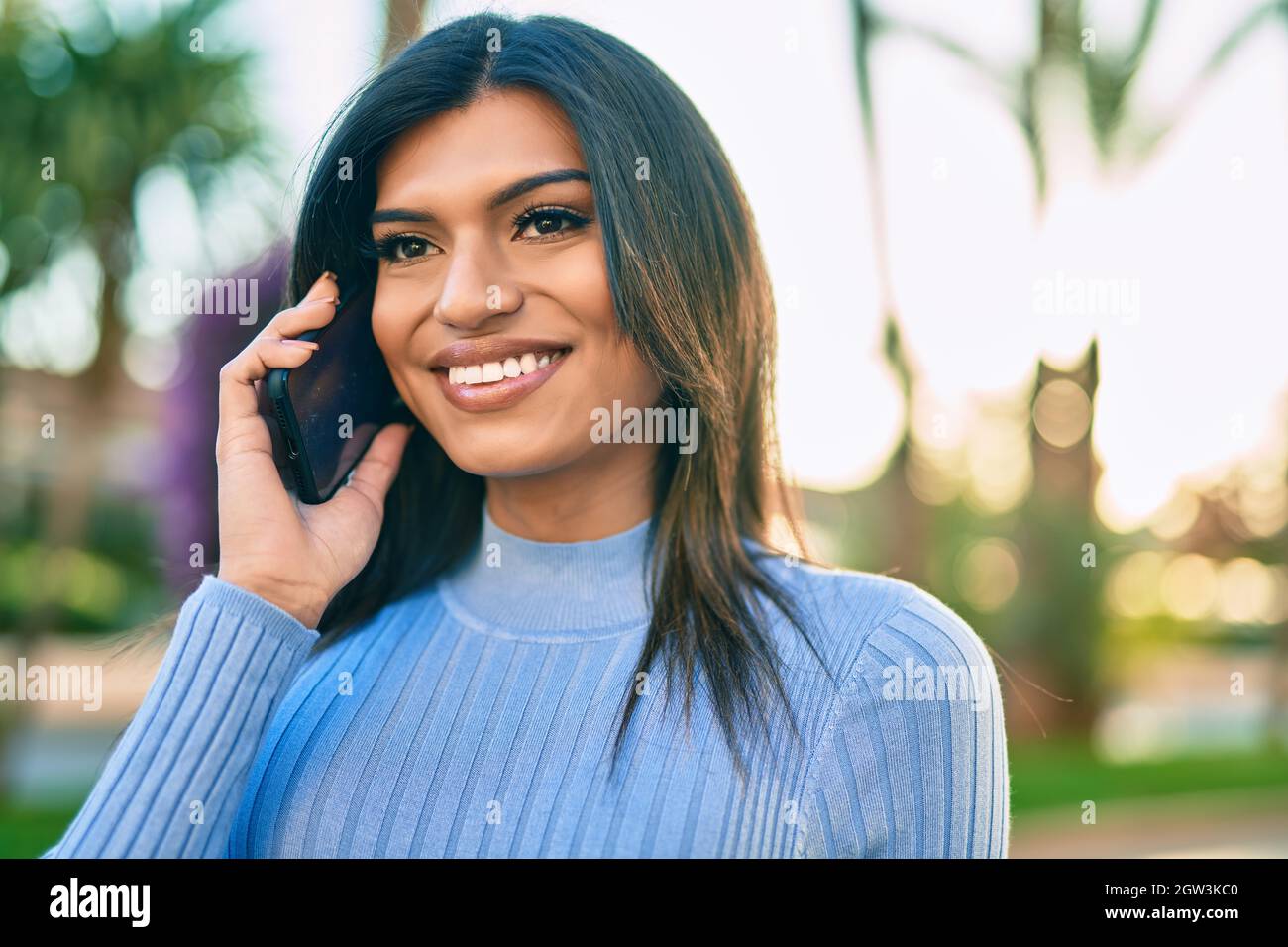Young hispanic woman speaking on the phone at the town Stock Photo - Alamy