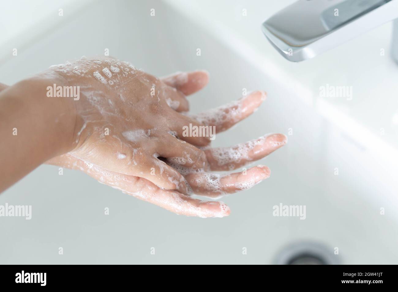 Woman Washing Hands In Sink Stock Photo