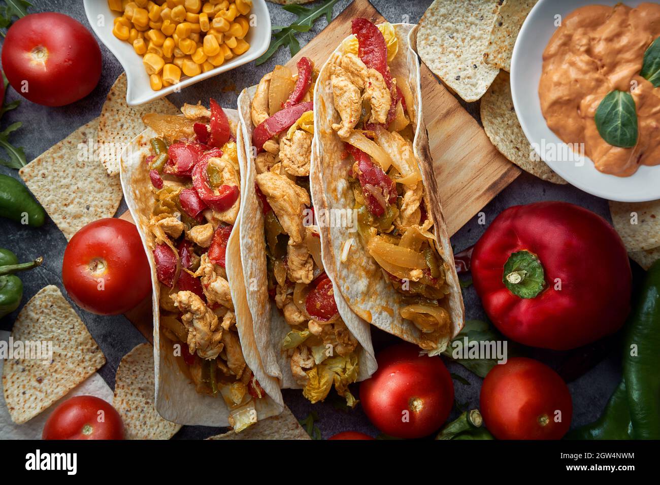 Still Life Of Three Fajitas Or Mexican Tacos With Meat, Pepper, Tomato, Spicy Pepper And Nachos. Stock Photo