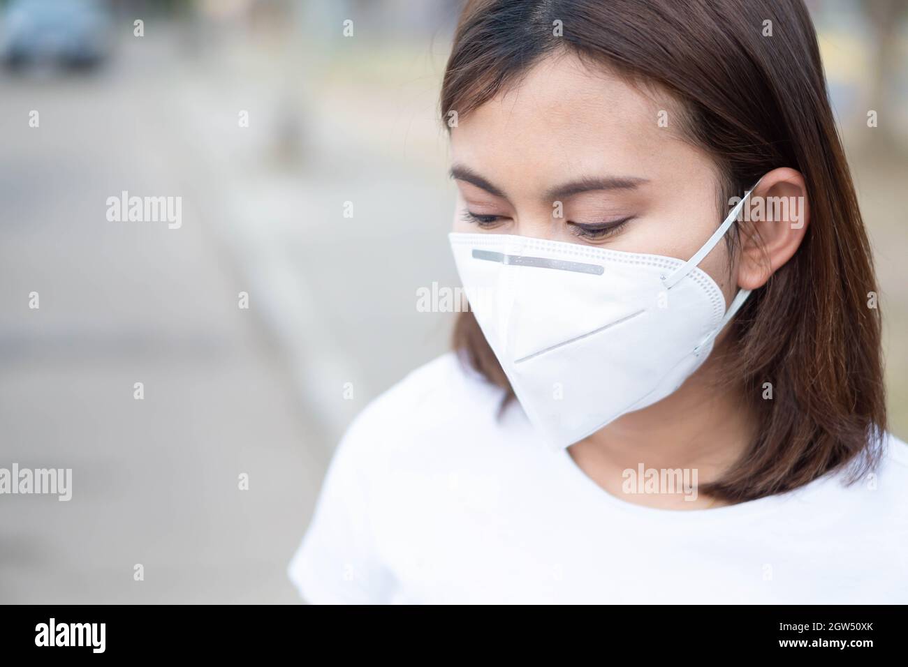 Mid Adult Woman Wearing Protective Mask Outdoors Stock Photo