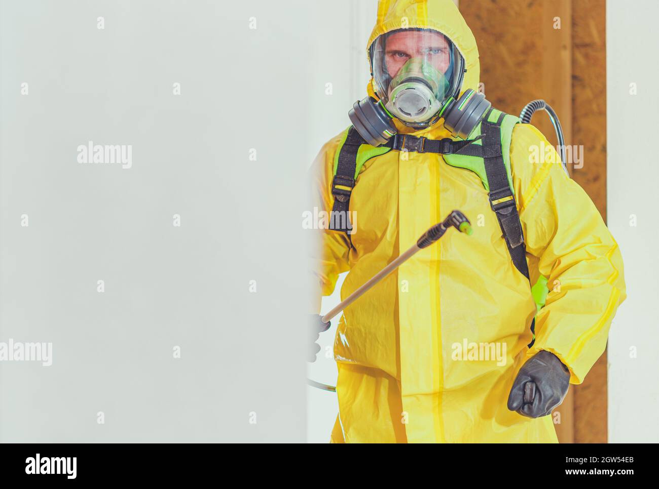 Man Wearing Protective Workwear Standing Against Wall Stock Photo