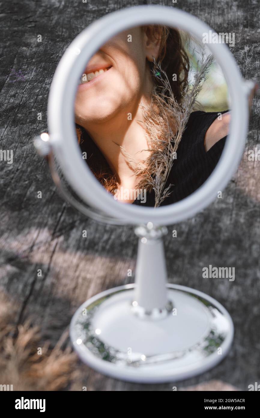 Body reflection at the round mirror on wooden table. Soul and spirit, romantic, tenderness outdoors concept. Copy space, beauty Stock Photo