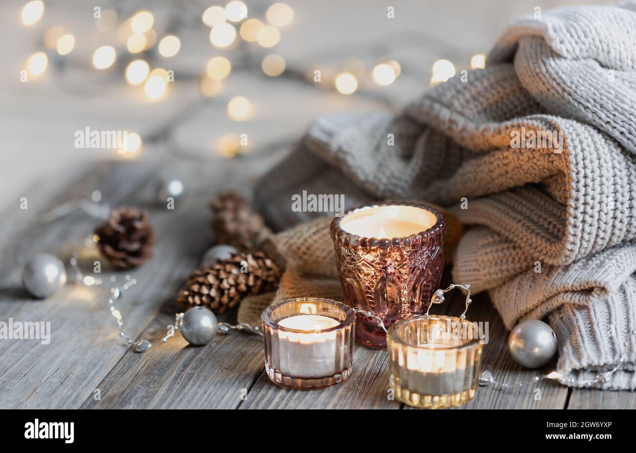 Cozy winter background with burning candles, decorative details