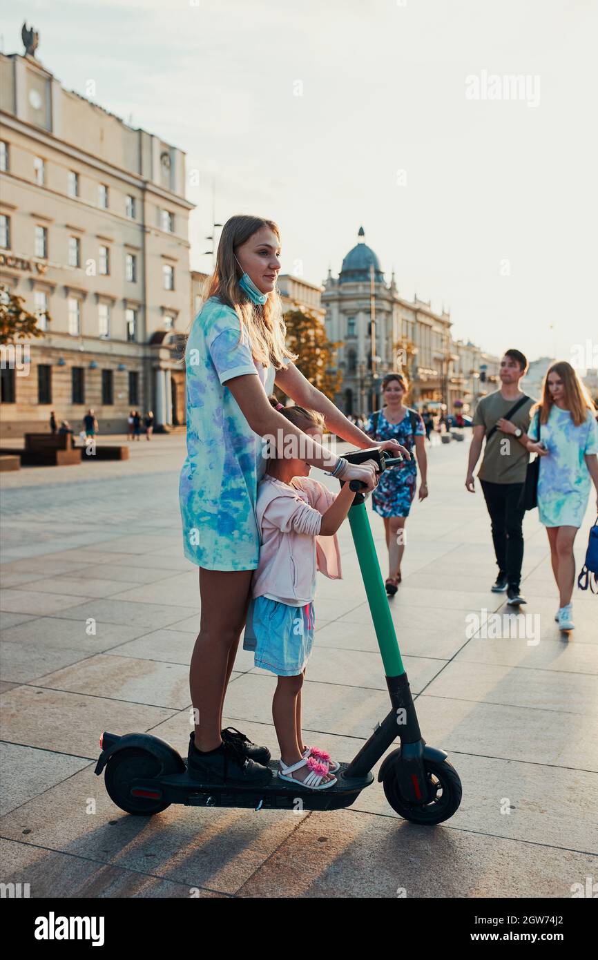 Teenager Girl And Her Sister Preschooler Riding An Electric Scooter In The  City Center Stock Photo - Alamy