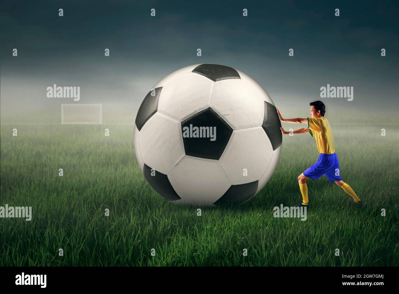 Digital Composite Image Of Man Pushing Large Soccer Ball On Field Stock Photo Alamy