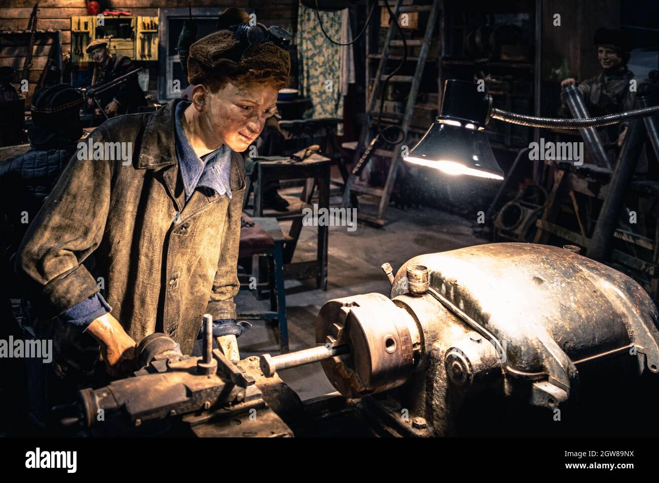 Young lad operating a lathe. WWII historical diorama titled 'Memory Speaks. A Way through the War'. Saint Petersburg. Stock Photo