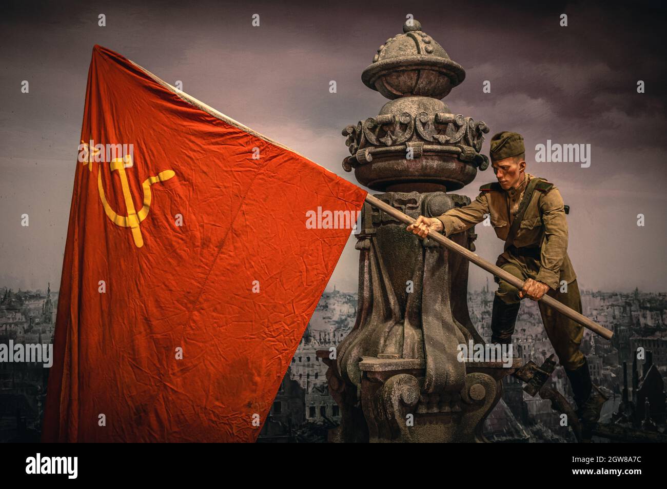 Young Soviet soldier waving a flag in captured Berlin. WWII historical diorama titled 'Memory Speaks. A Way through the War'. Saint Petersburg. Stock Photo