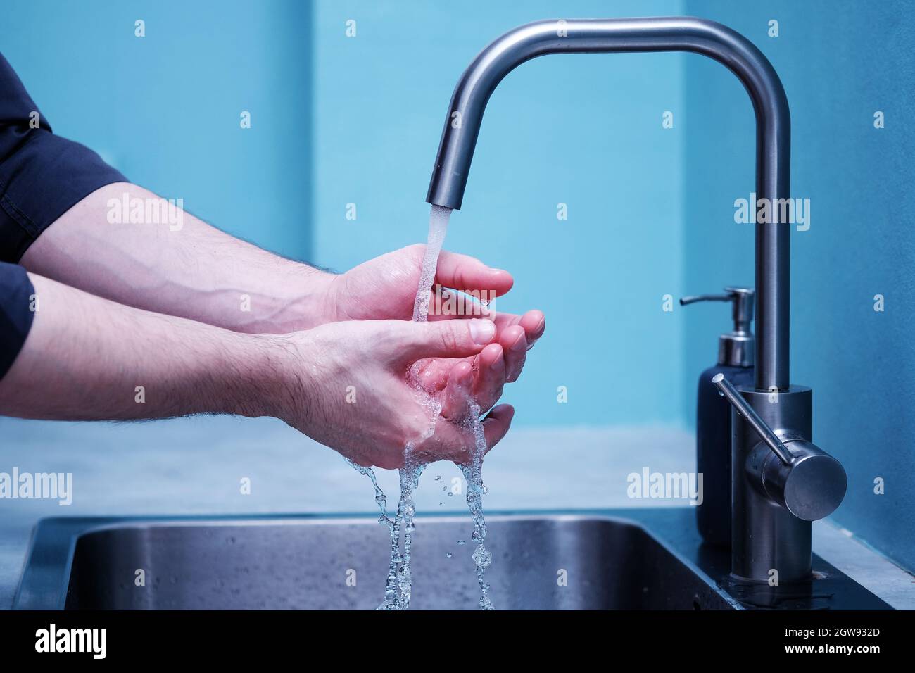 One Young Man Washes His Hands - Before Eating Or After Eating Closeup In The Kitchen Stock Photo