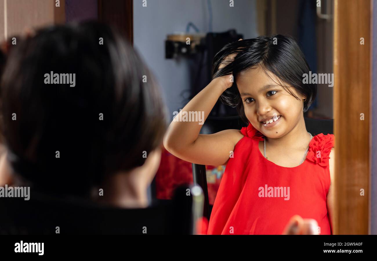 A Cute Indian Girl Child In Red Dress Is Styling Hair In Front Of Mirror With Smiling Face Stock Photo - Alamy A Cute Indian Girl Child In Red Dress Is Styling Hair In Front Of Mirror With Smiling Face Stock Photo - Alamy