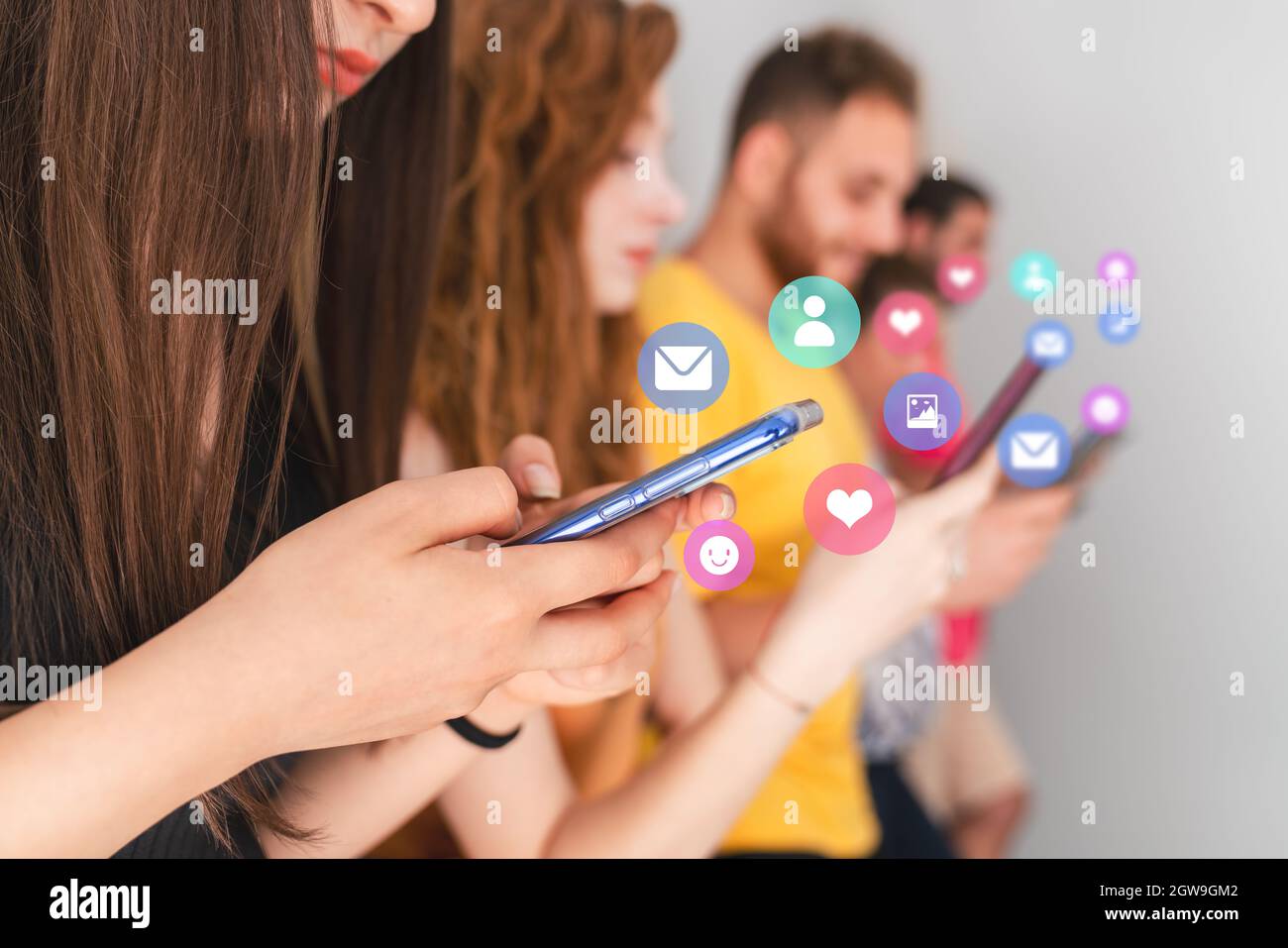 Group of friends standing and looking to their mobile phones. Social media and technology addiction concept. High quality photo Stock Photo