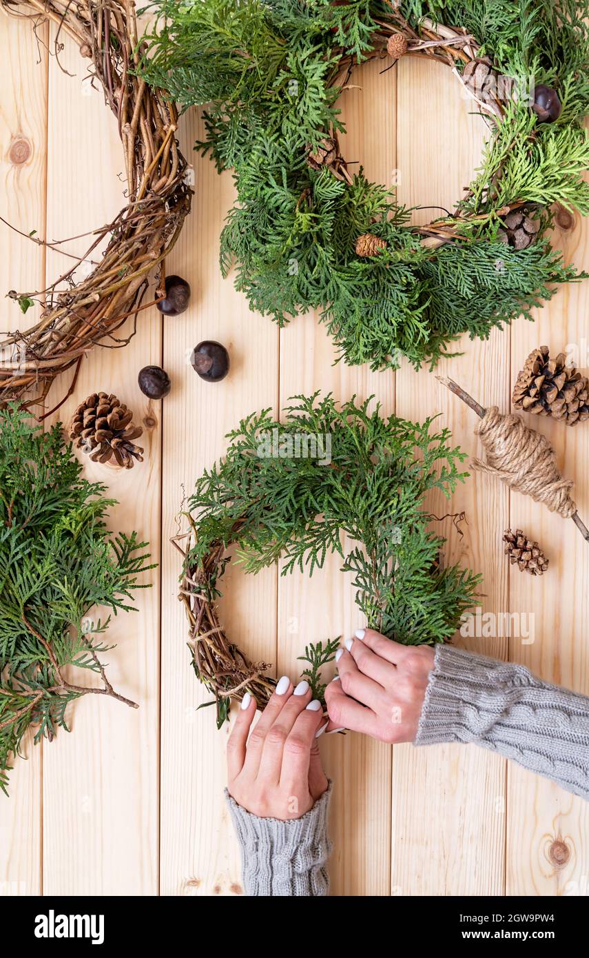 Hands Making Christmas Or New Year Diy Wreath With Fir Tree Branches,  Vines, Pine Cones Top View Stock Photo - Alamy