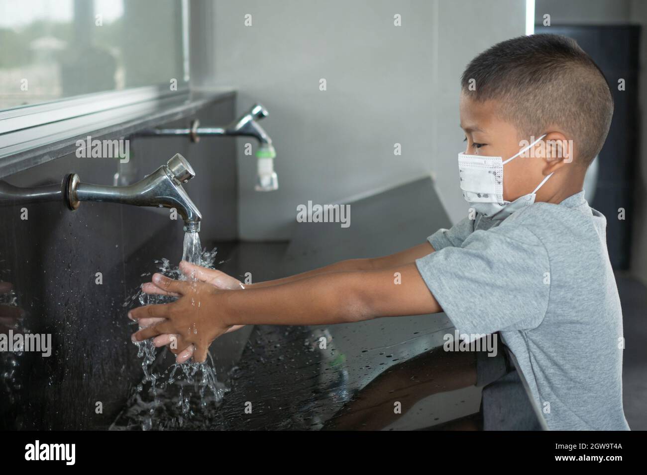 Boy is washing his hands at a tap hires stock photography and images Alamy