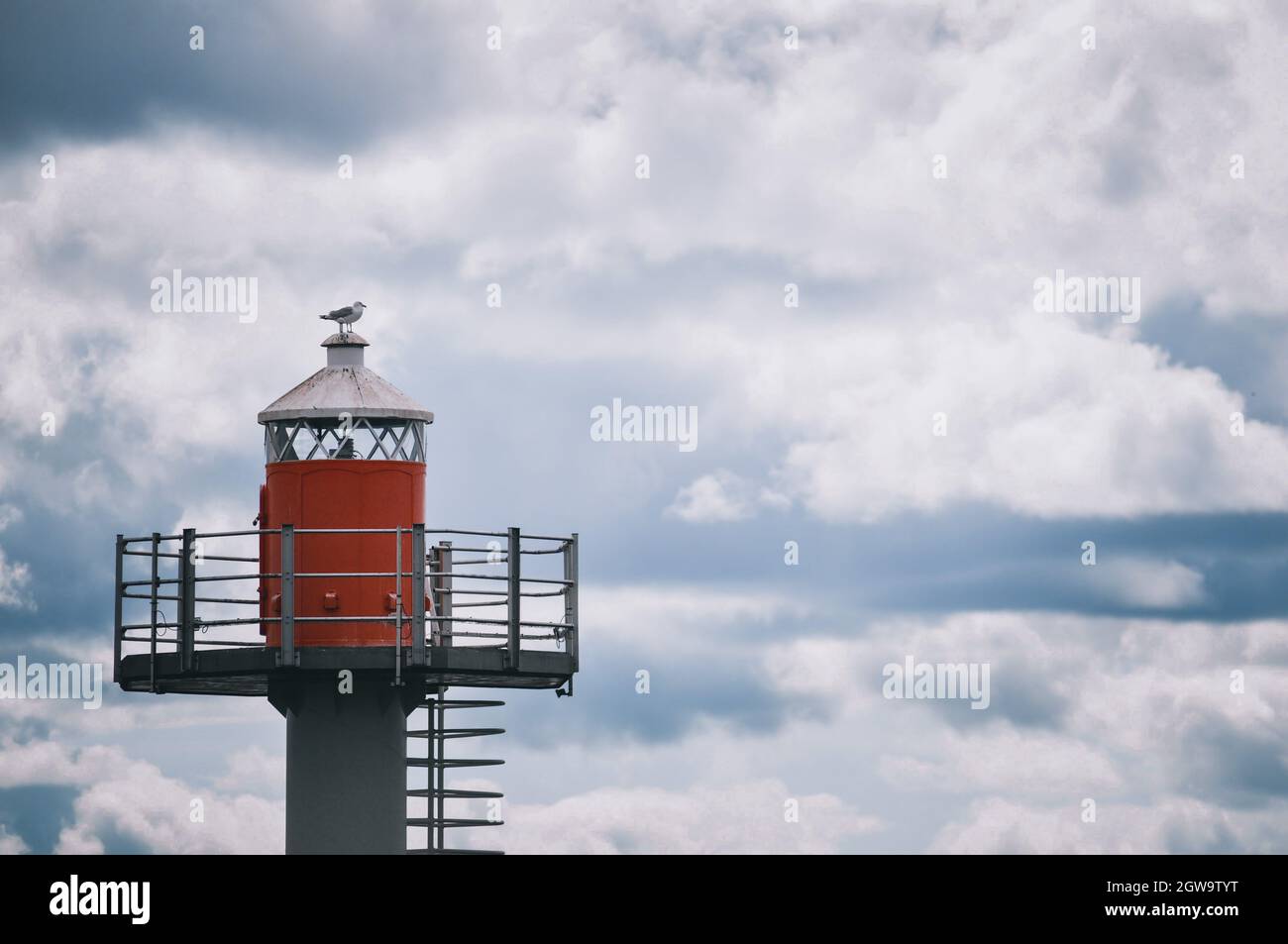 Lighthouse By Building Against Sky Stock Photo