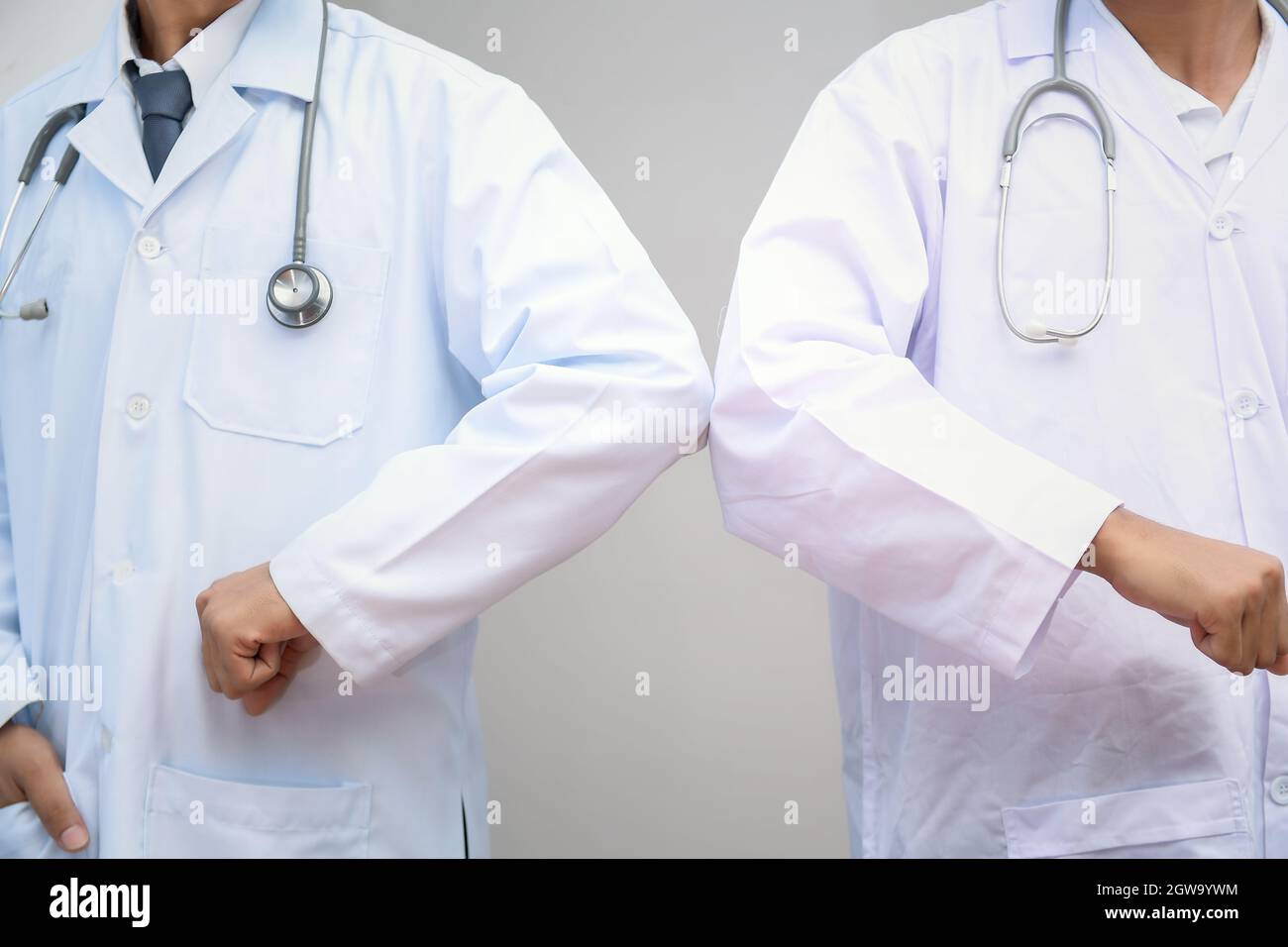 Elbow Bump. New Novel Greeting To Avoid The Spread Of Coronavirus. Two Doctor Friends Meet Stock Photo