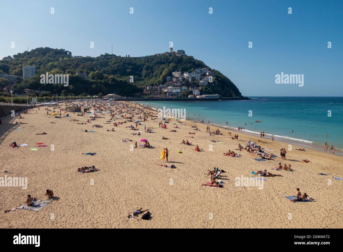 Ondarreta beach in San Sebastian, with Igueldo mountain in the background Stock Photo