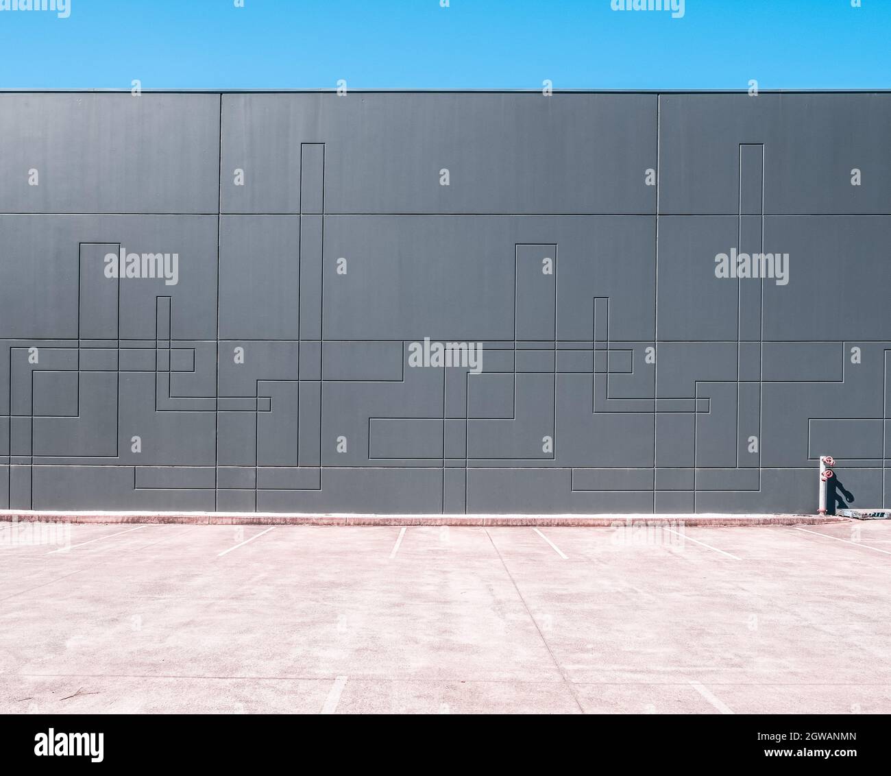Unoccupied Parking Lot Next To Warehouse Wall With Copy Space - Industrial Architecture Minimalism Stock Photo