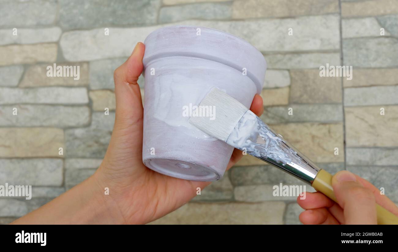 painting white paint onto the pot Stock Photo