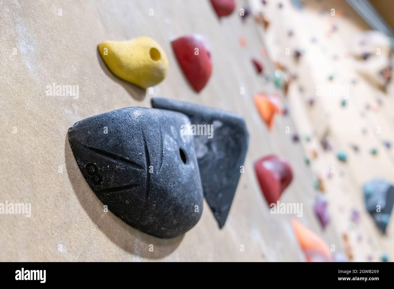 Closeup Of Black Pocket Climbing Hold On Blurred Background Stock Photo