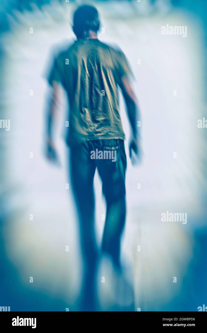 unknown man walking away, with a blur zoom effect Stock Photo - Alamy