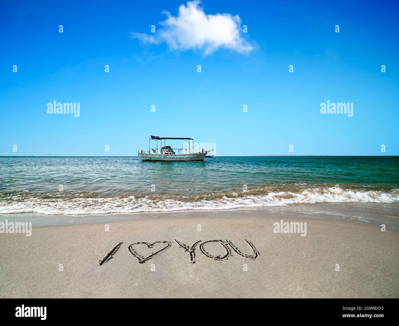 The Boat Is Anchoring At The Beautiful Beach On A Sunny Day Stock Photo