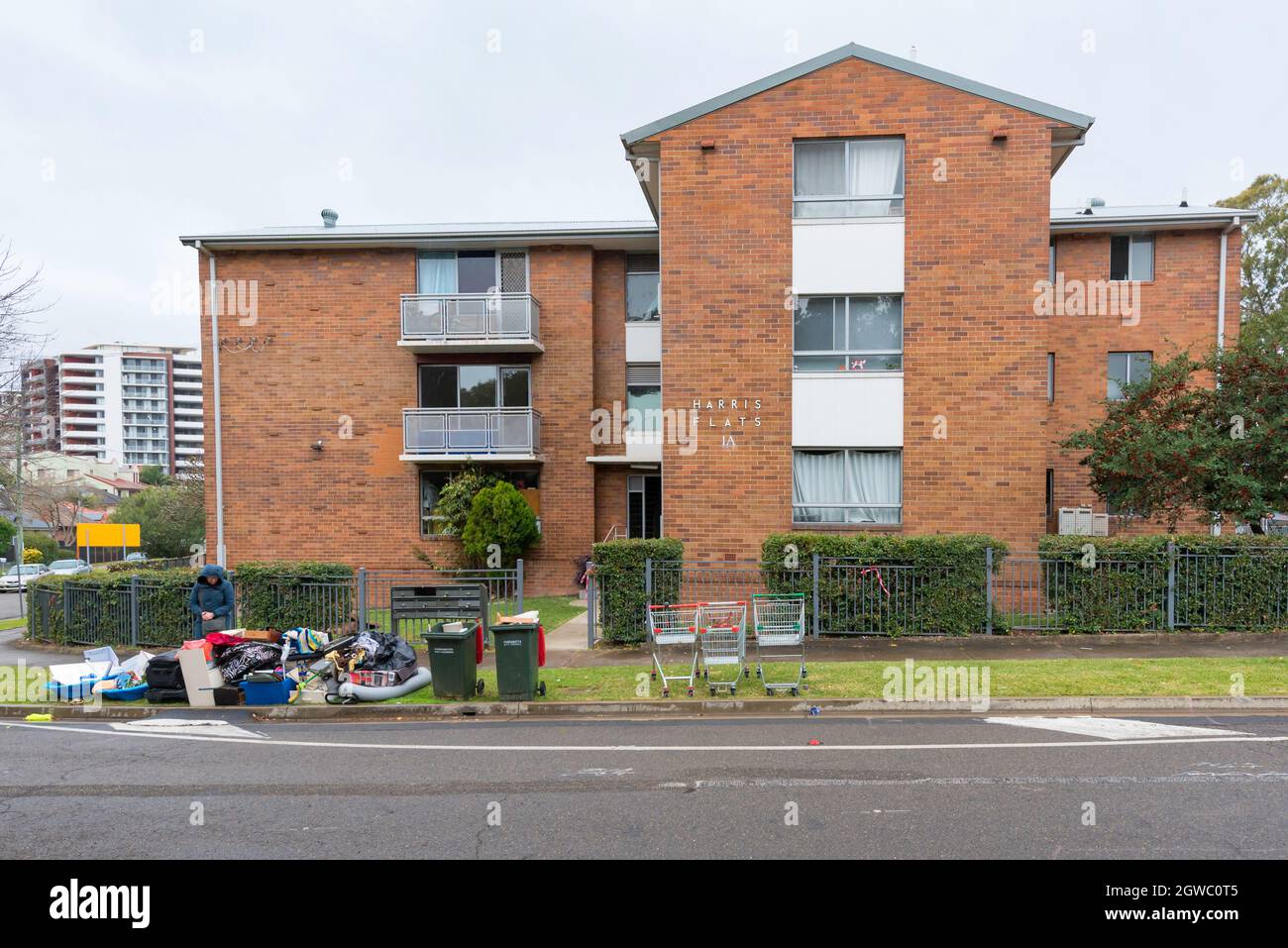 A woman inspects rubbish left on the footpath outside an apartment block in Parramatta, New South Wales, Australia Stock Photo