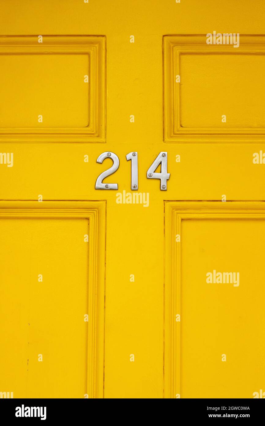 House Number 214 On A Yellow Wooden Front Door In London Stock Photo