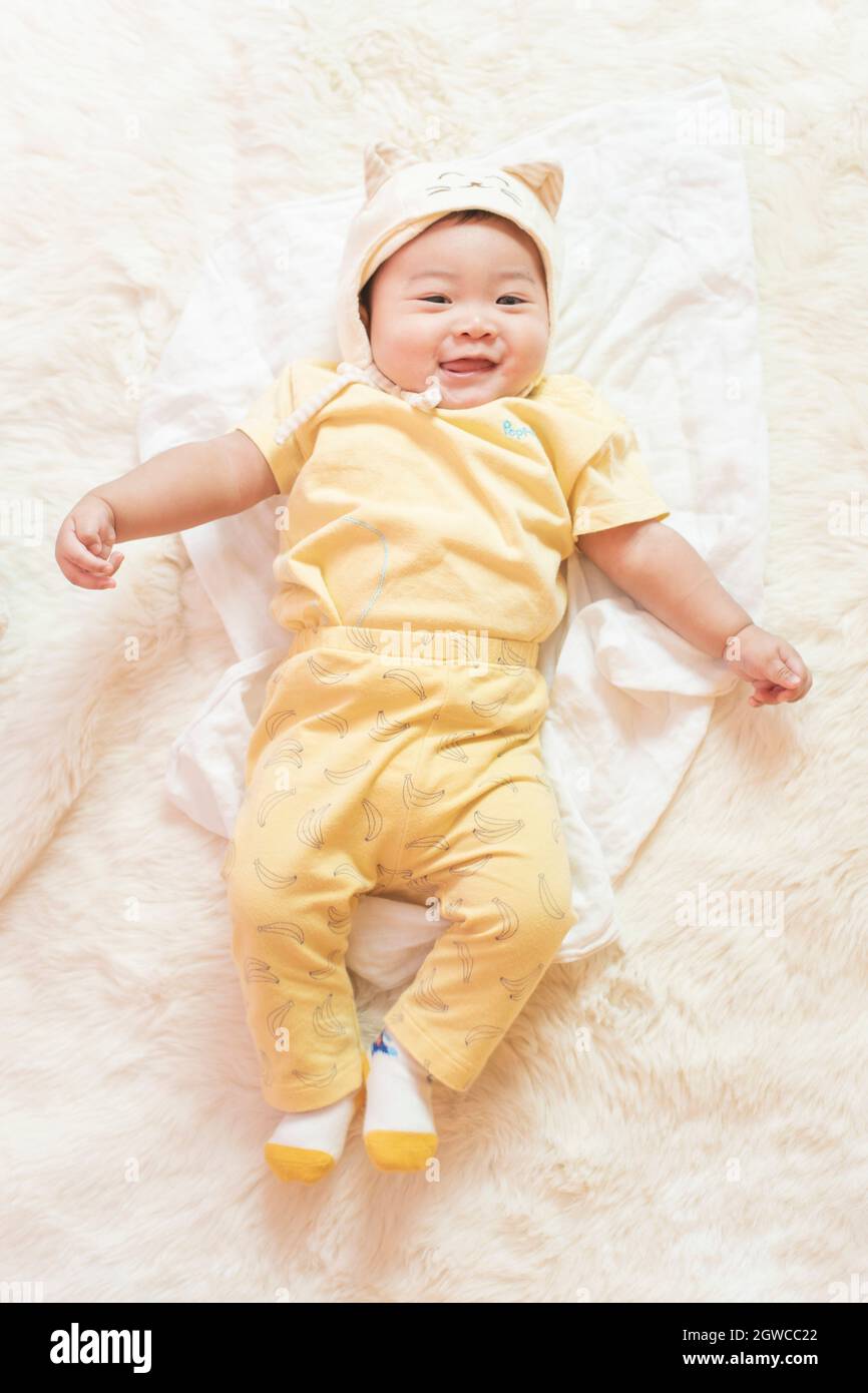 High Angle View Of Cute Baby Boy Lying On Bed At Home Stock Photo