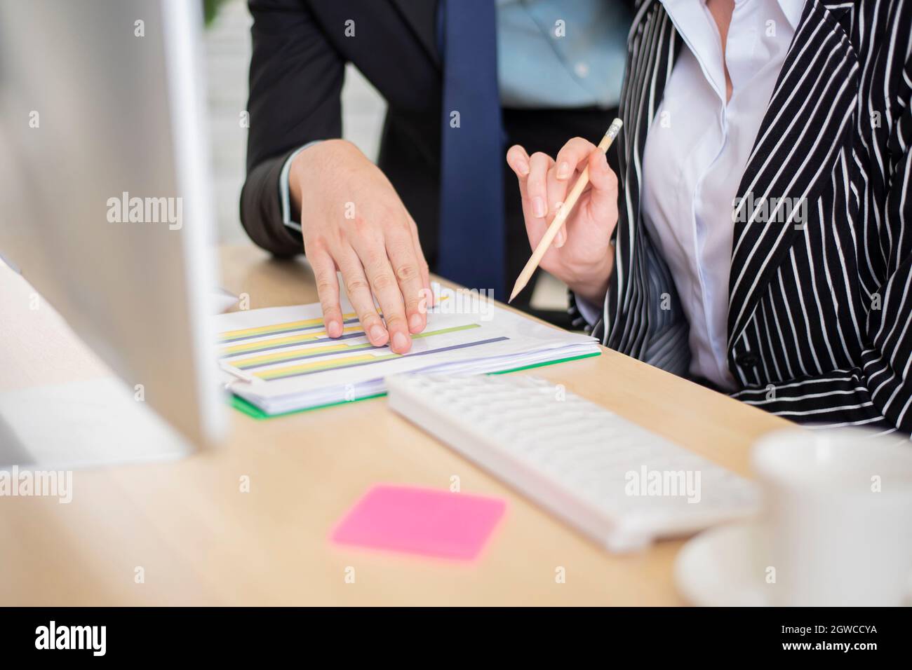 Midsection Of Businesswoman And Colleague Working In Office Stock Photo
