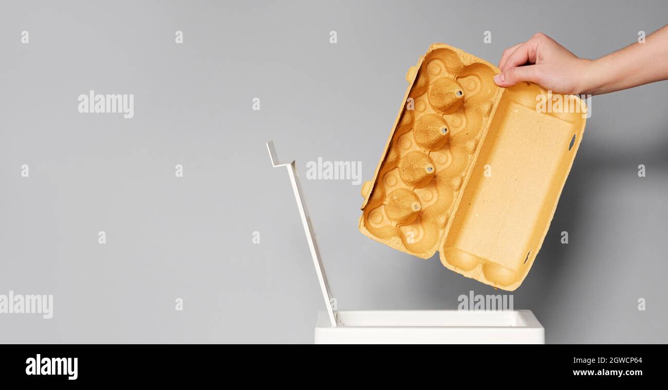 Hand Puts Empty Egg Box In The Bin For Recycling. Activist Taking Care