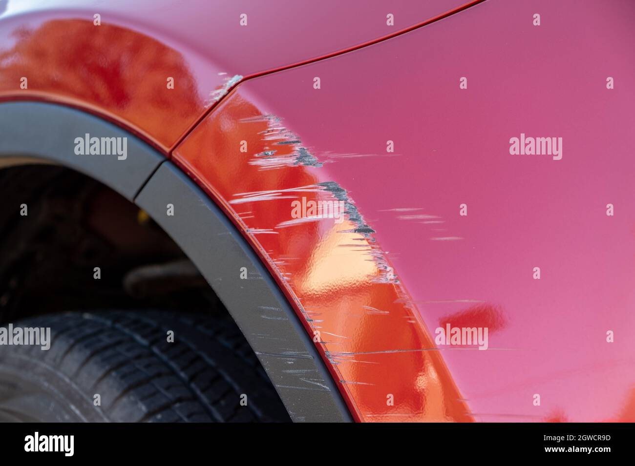 Closeup Of Deep Scratches In Red Paint Of Car Bumper Stock Photo