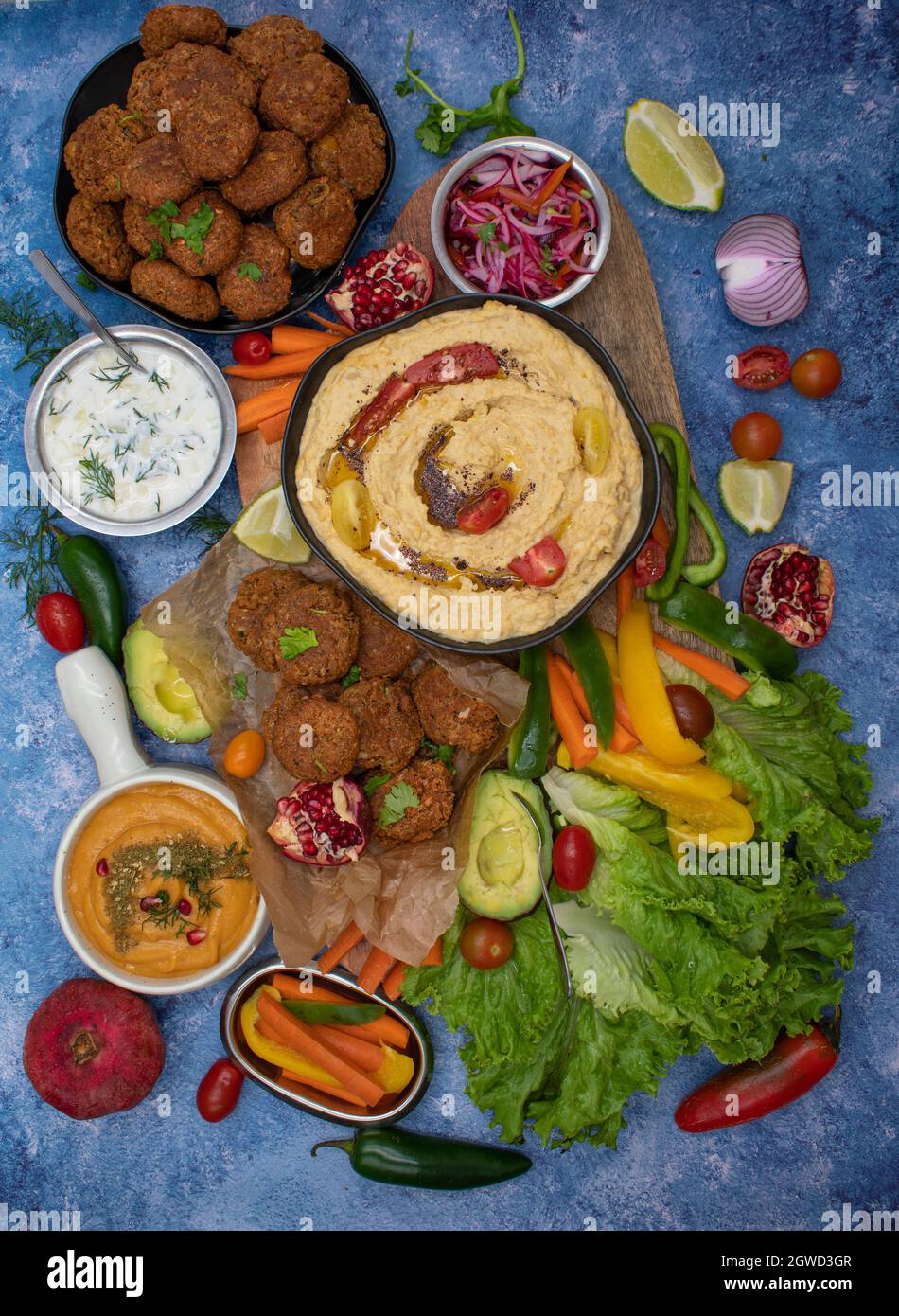 Mediterranean food spread with hummus, falafel, roasted pepper dip, yogurt sauce, crudites Stock Photo