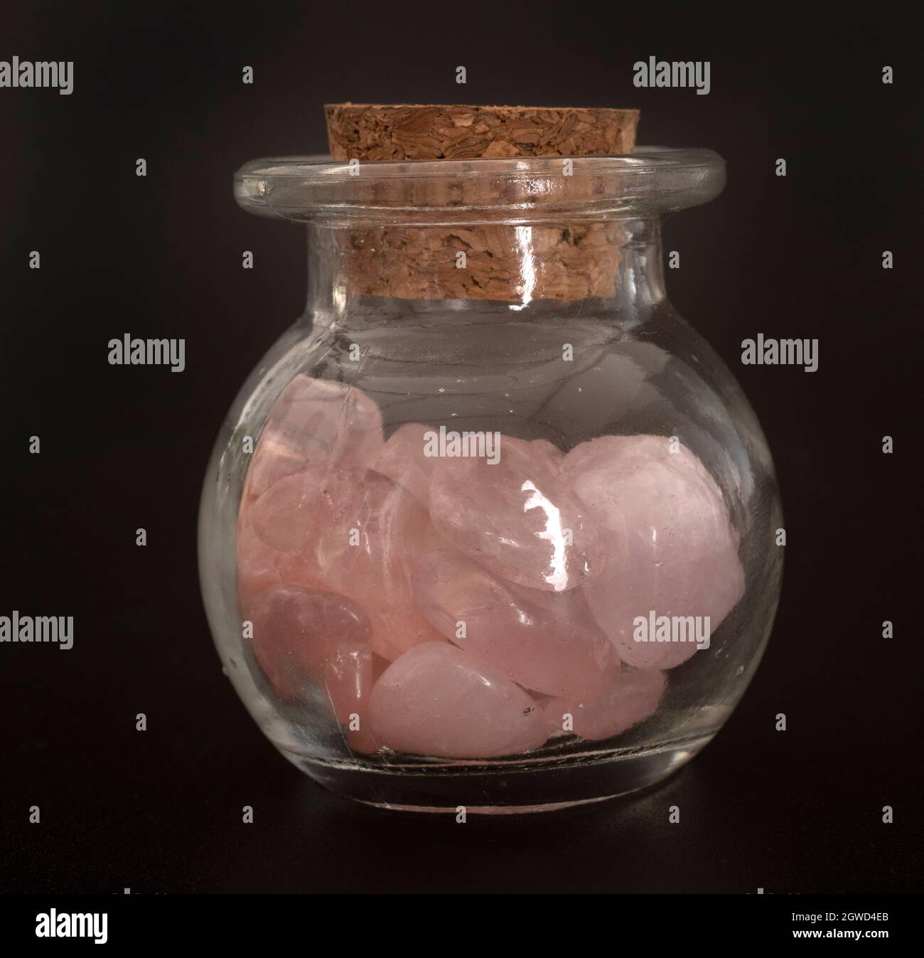Close-up Of Stones In Glass Jar On Table Against Black Background Stock Photo