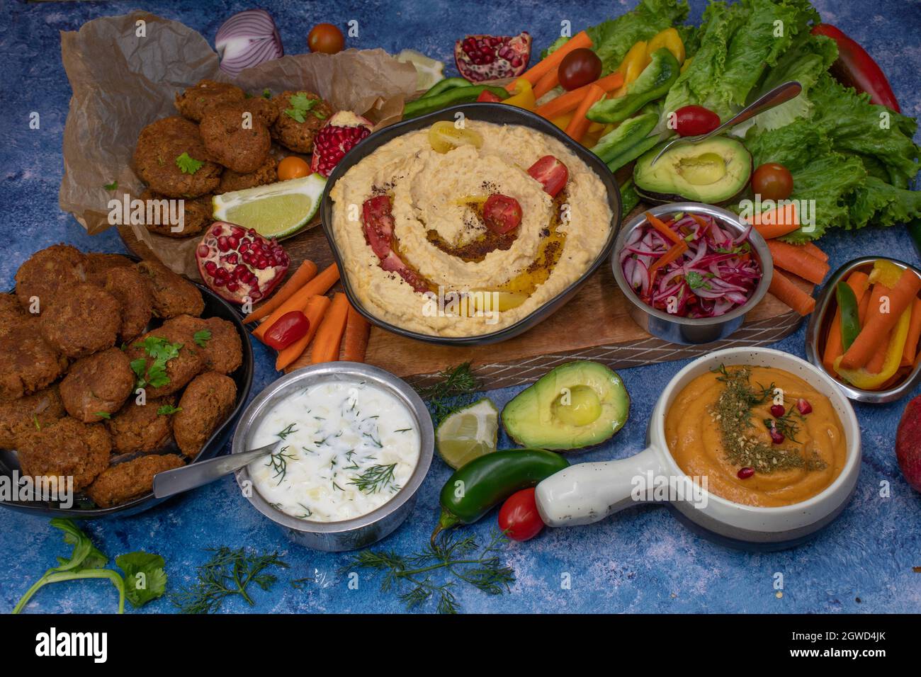 Mediterranean food spread with hummus, falafel, roasted pepper dip, yogurt sauce, crudites Stock Photo