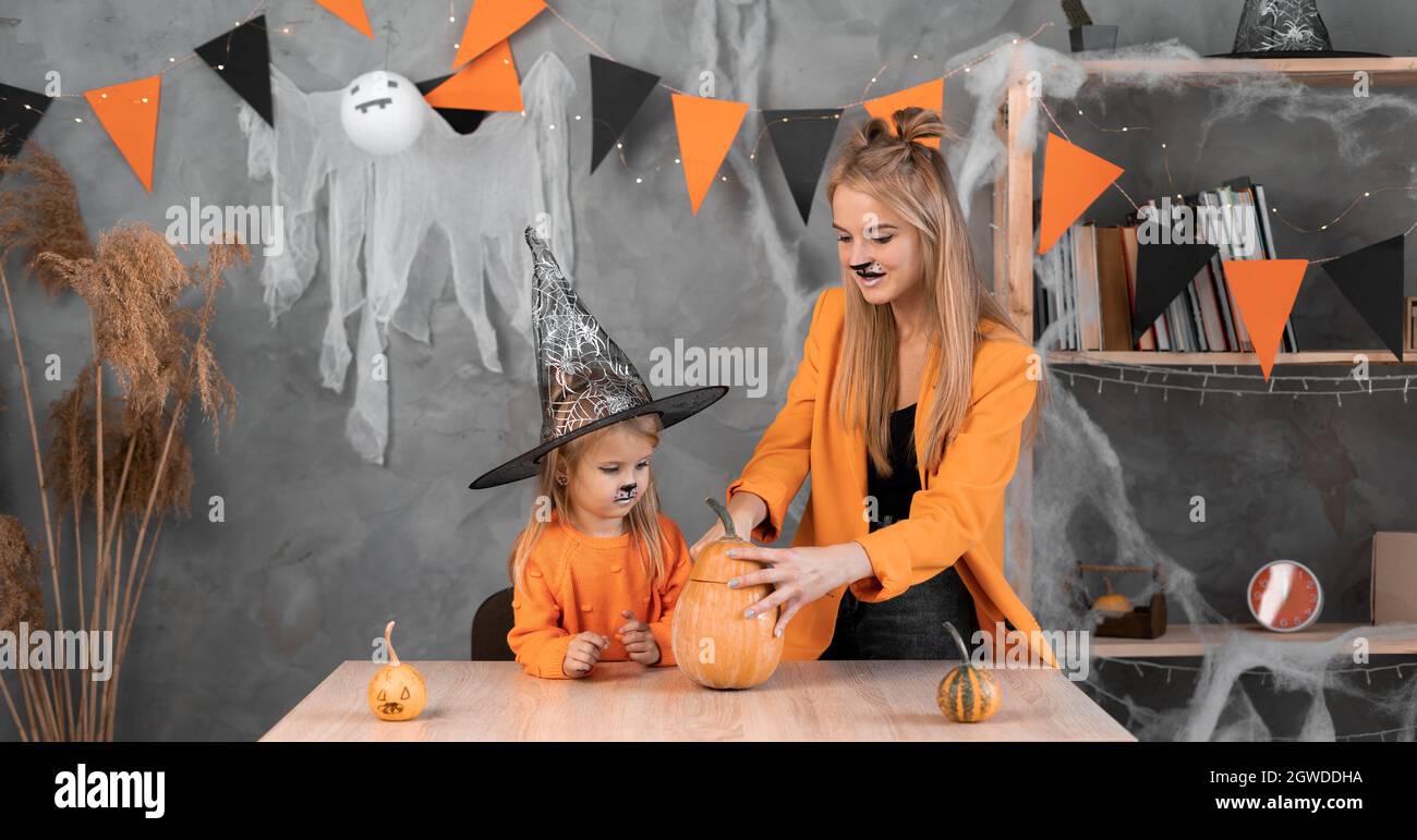 Mom and daughter make a pumpkin jack-o-lantern for Halloween ...