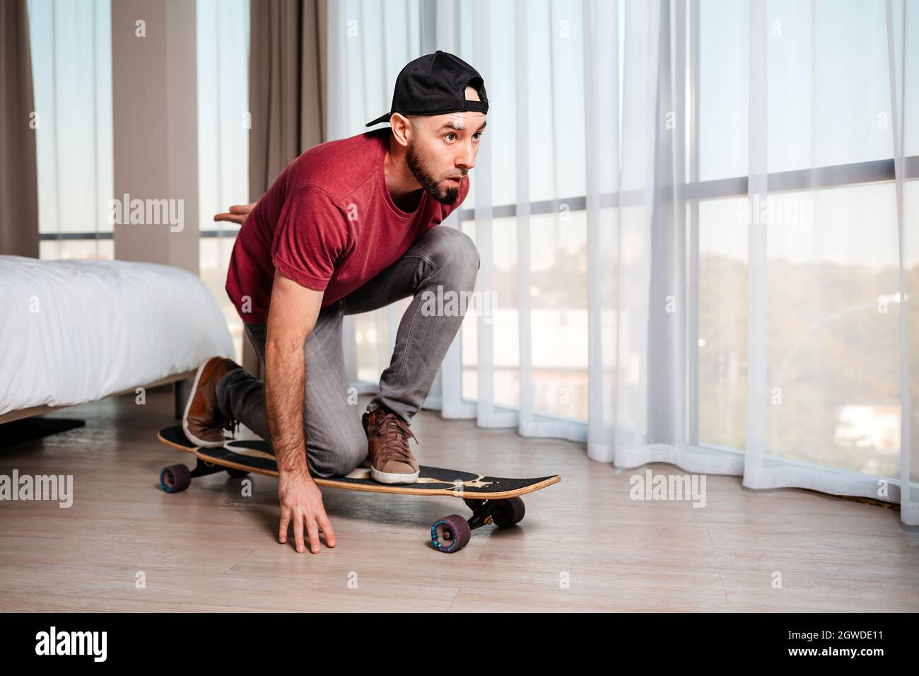 A young man poses on a longboard, imagining that he is driving down the  street. Home interior. Indoor. Concept of quarantine and activity at home  Stock Photo - Alamy
