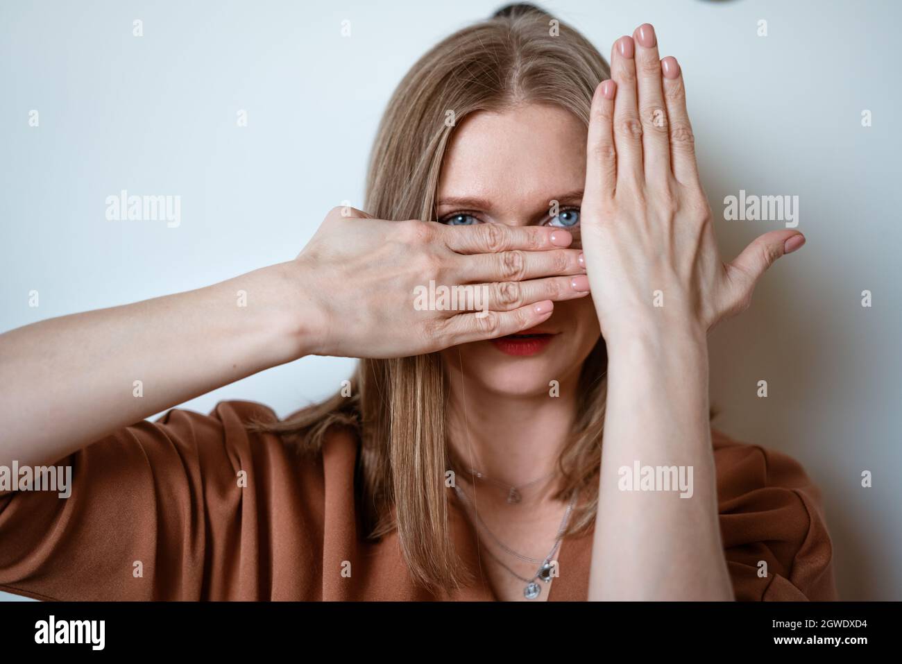 Woman Covers Her Face With Her Hands Stock Photo