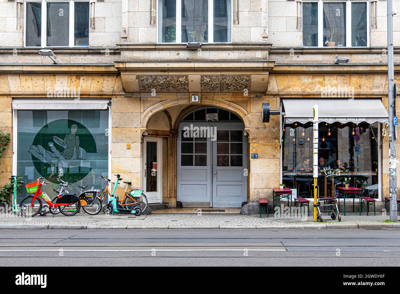 Tak tak Polish deli in Historic old apartment building and rental bikes and scooters on pavement, Brunnenstrasse 6, Mitte, Berlin, Germany Stock Photo