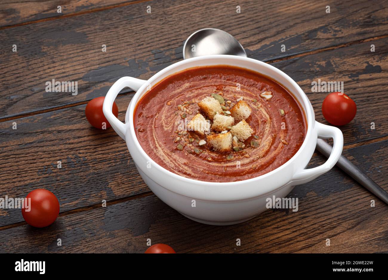 Bowl of tomato soup on wooden background Stock Photo