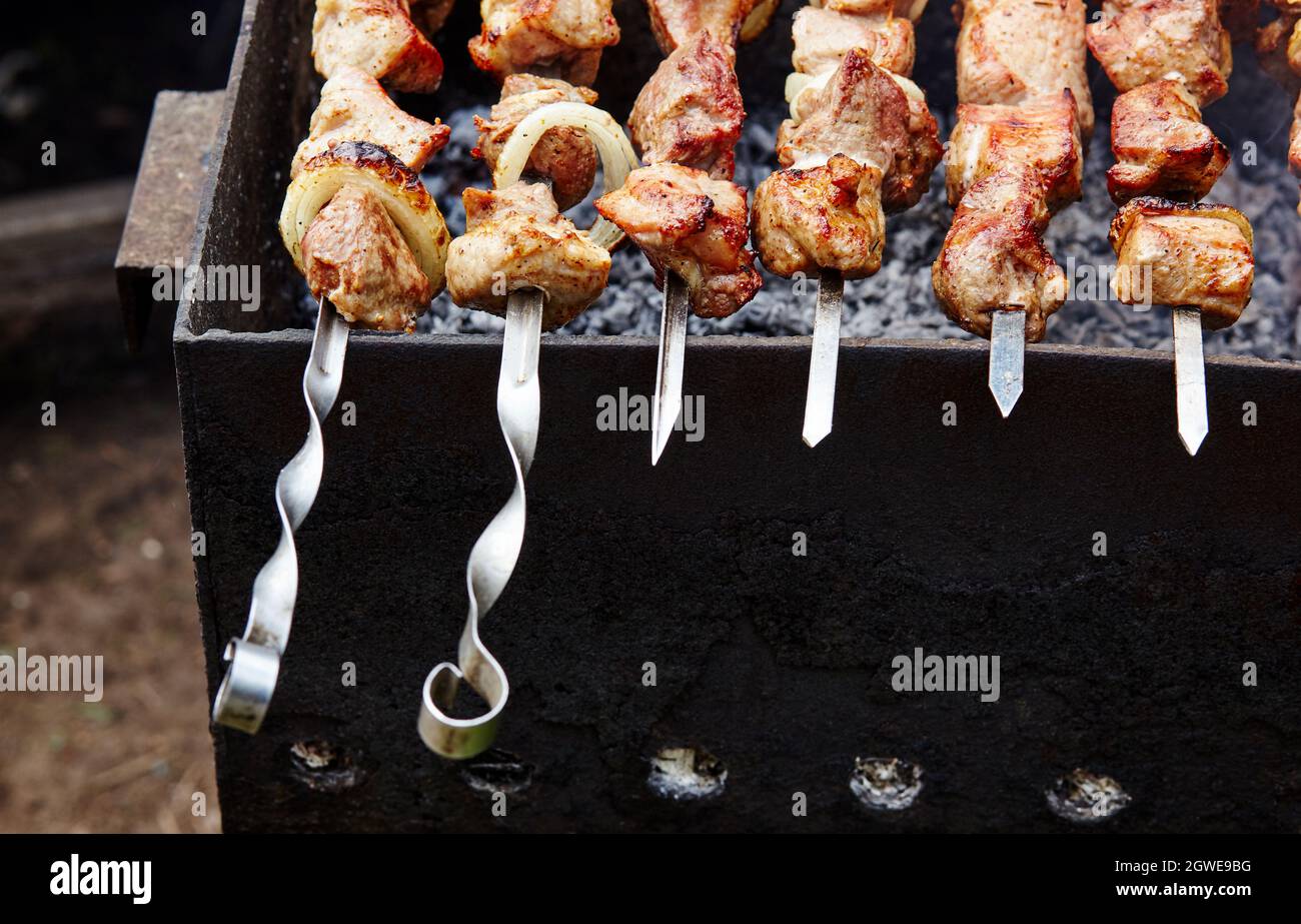 Grilling marinated shashlik on a grill. Shashlik is a form of Shish kebab  popular in Eastern, Central Europe and other places. Shashlyk meaning skewer  Stock Photo - Alamy